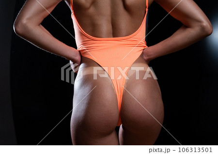 A faceless woman in an orange swimsuit demonstrates the result of an instant tan A faceless woman in an orange swimsuit demonstrates the result of an instant tan 106313501