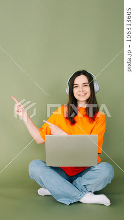Young professional woman confidently working on laptop, pointing to empty space for text and Young professional woman confidently working on laptop, pointing to empty space for text and 106313605