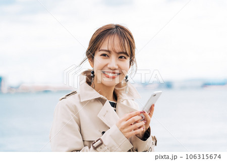 屋外でスマホを持つ若い女性 屋外でスマホを持つ若い女性 106315674