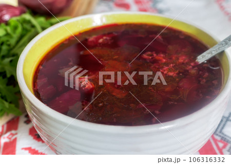 Ukrainian borscht in a ceramic plate on the kitchen table. Ukrainian borscht in a ceramic plate on the kitchen table. 106316332