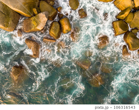 Waves crashing on seashore rocks,Top view sea surface waves background Waves crashing on seashore rocks,Top view sea surface waves background 106316543
