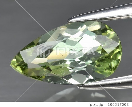 Natural gemstone green tourmaline on gray background 106317008