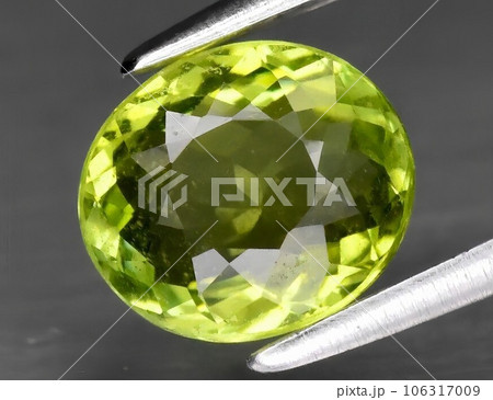 Natural gemstone green tourmaline on gray background 106317009
