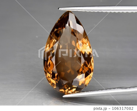 Natural gemstone orange topaz on a gray background. Imperial topaz, champagne topaz 106317082