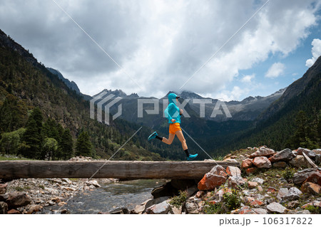 Woman trail runner cross country running in high altitude mountains Woman trail runner cross country running in high altitude mountains 106317822