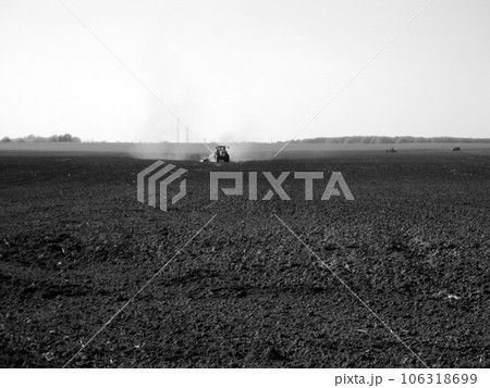 Plowed field by tractor in black soil on open countryside nature Plowed field by tractor in black soil on open countryside nature 106318699