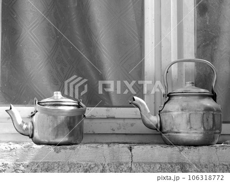 Copper teapots standing to concrete sill, kettles on street shop window before glass 106318772
