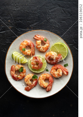 Shrimps, top shot. Cooked shrimp with lime on a white plate Shrimps, top shot. Cooked shrimp with lime on a white plate 106319052