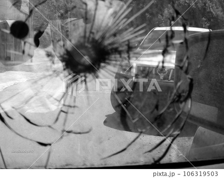 Big crack to windshield of car from fragment military sniper bullet 106319503