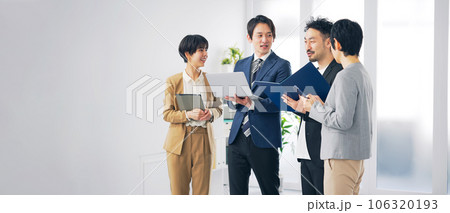 オフィスで会話するビジネスパーソンのグループ 106320193