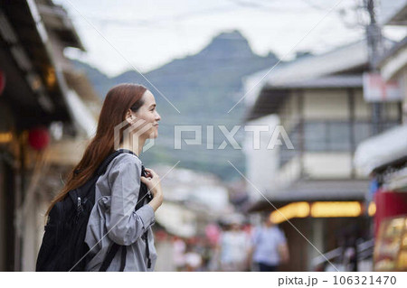 商店街を歩くリュックを背負った外国人の旅行者 商店街を歩くリュックを背負った外国人の旅行者 106321470