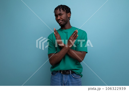young brunette african man with dreadlocks in a t-shirt with arms crossed young brunette african man with dreadlocks in a t-shirt with arms crossed 106322939