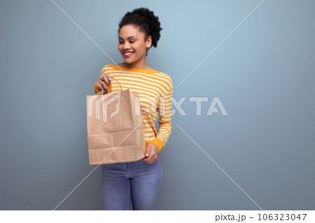 afro brunette latin young woman holding craft bag with printable mockup 106323047