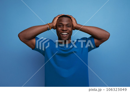 A 30 year old dark-skinned American man dressed in a basic T-shirt poses in front of copy space A 30 year old dark-skinned American man dressed in a basic T-shirt poses in front of copy space 106323049