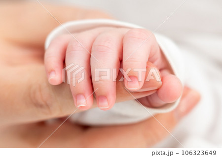 Innocence meets protection in newborn's grasp. Concept of mother-child connection Innocence meets protection in newborn's grasp. Concept of mother-child connection 106323649