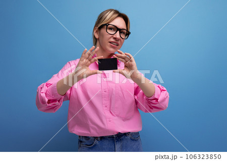 young caucasian blonde secretary woman with ponytail hairstyle and glasses dressed in a pink shirt 106323850