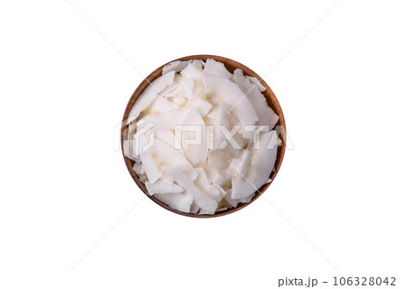 White dry coconut flakes in a wooden bowl prepared for making desserts 106328042