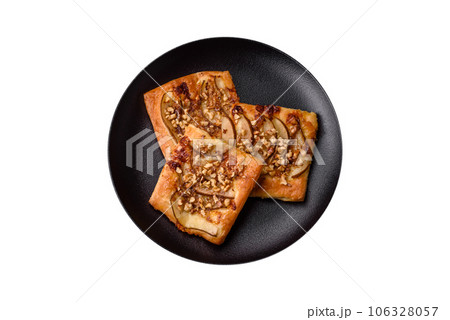 Delicious fresh sweet pie or pizza with pear, brie cheese, honey and nuts Delicious fresh sweet pie or pizza with pear, brie cheese, honey and nuts 106328057