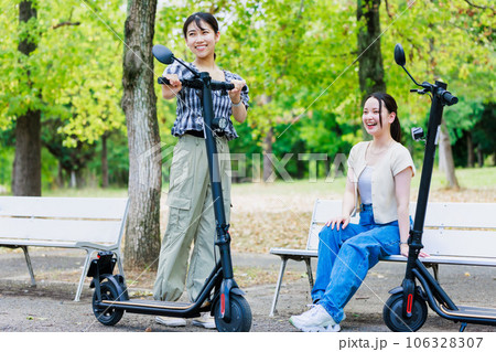 友達と電動キックボードに乗る女子大生 106328307