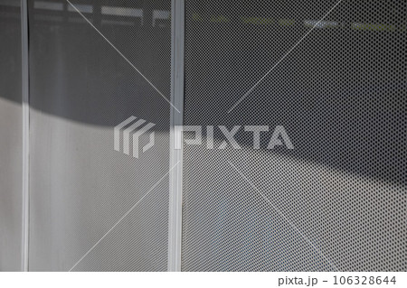 Perforated metal panel with round holes punctuated by a vertical strip. Perforated metal panel with round holes punctuated by a vertical strip. 106328644