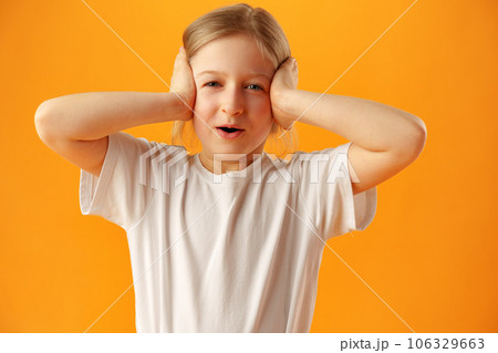 Little excited shocked girl against yellow background Little excited shocked girl against yellow background 106329663