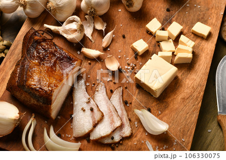 still life of food in a rural style on a dark wood background, sliced lard and garlic, cheese and onion, concept of fresh vegetables and healthy food still life of food in a rural style on a dark wood background, sliced lard and garlic, cheese and onion, concept of fresh vegetables and healthy food 106330075