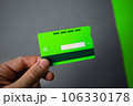 Green plastic bank card on a gray background. Mockup. Plastic card with chip. 106330178