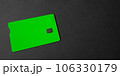 Green plastic bank card on a gray background. Mockup. Plastic card with chip. 106330179