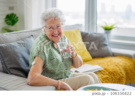 Senior woman drinking water to better manage her diabetes. 106330822