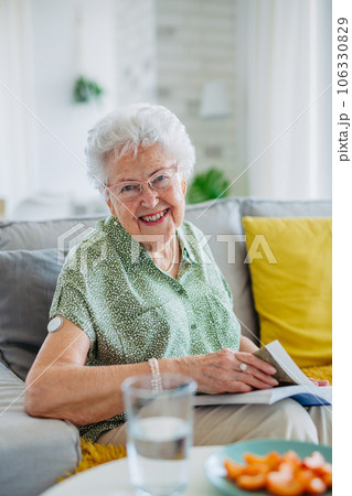 Diabetic senior patient using continuous glucose monitor to check blood sugar level at home. 106330829