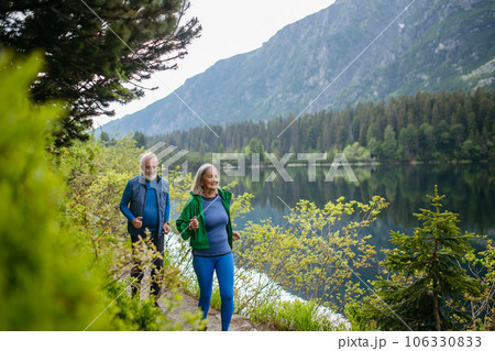 Senior couple running by the lake in the mountains. Senior couple running by the lake in the mountains. 106330833