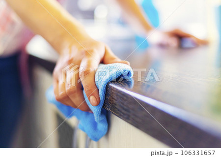 Woman hand cleaning the counter in the kitchen with a blue microfiber cloth Woman hand cleaning the counter in the kitchen with a blue microfiber cloth 106331657