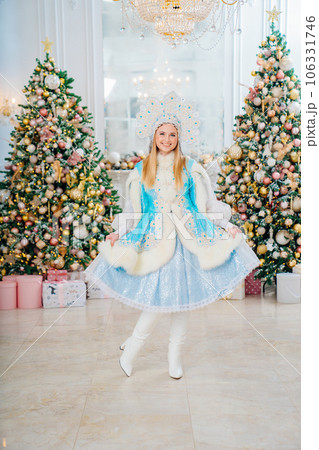 Snow Maiden in costume with short skirt and kokoshnik. room with christmas tree. 106331746
