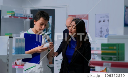 Asian customer in need of prescription drugs informations in apothecary, asking chemist checking pharmaceutical products inventory. Pharmacy technician helping client with recommendations Asian customer in need of prescription drugs informations in apothecary, asking chemist checking pharmaceutical products inventory. Pharmacy technician helping client with recommendations 106332830