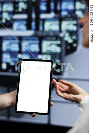 Close up of mock up tablet used by supervisor and assistant in cloud computing server facility delivering massive computational power, capable of processing and storing vast amounts of datasets 106332843