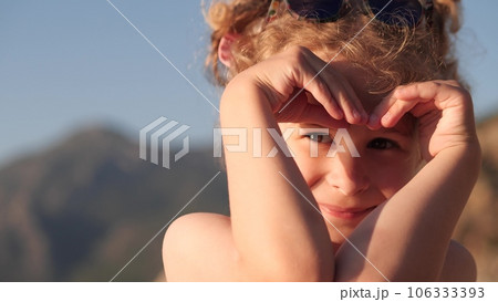 Beautiful little girl makes heart shape with her hands 106333393
