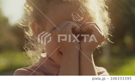 Cute little girl makes a heart shape with her hands Cute little girl makes a heart shape with her hands 106333395