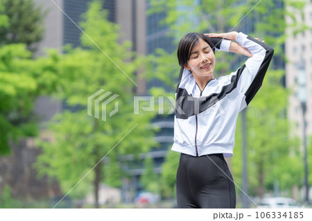 都会でジョギング前にストレッチをする若い女性 都会でジョギング前にストレッチをする若い女性 106334185