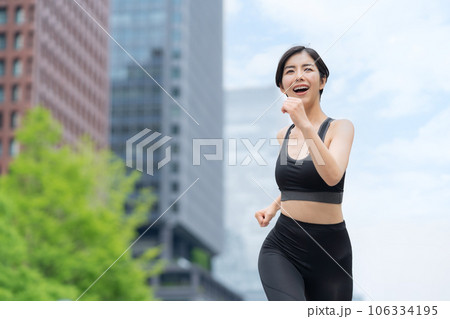 都会をジョギングする若い女性 106334195