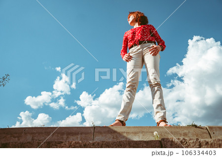 girl against the sky in a red blouse bottom view 106334403