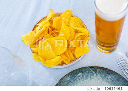 Potato chips and beer served on table Potato chips and beer served on table 106334614