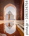 tourist standing in front entrance gate of Taj Mahal indian palace. Islam architecture. Door to the mosque  106334764