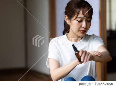 虫除けスプレーをする女性 106337650