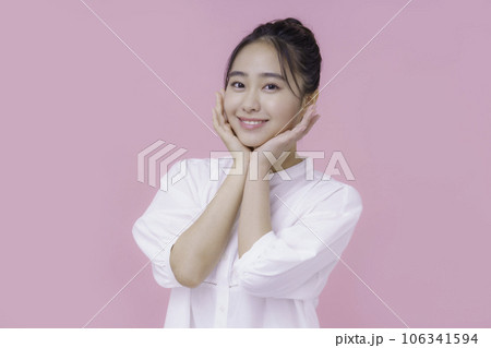 ピンクバックの若い女性のポートレート 106341594