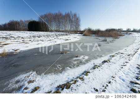 Frozen snow and water on a rural field 106342406