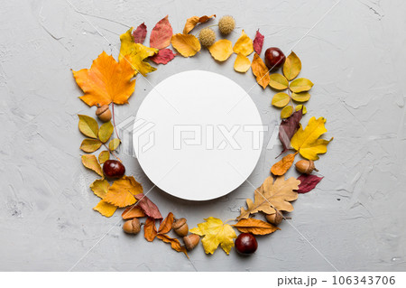 Autumn composition with round paper blank and dried leaves on table. Flat lay, top view, copy space 106343706