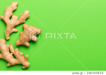 Finely dry Ginger powder in bowl with green leaves isolated on colored background. top view flat lay Finely dry Ginger powder in bowl with green leaves isolated on colored background. top view flat lay 106344658