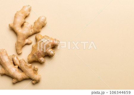 Finely dry Ginger powder in bowl with green leaves isolated on colored background. top view flat lay Finely dry Ginger powder in bowl with green leaves isolated on colored background. top view flat lay 106344659