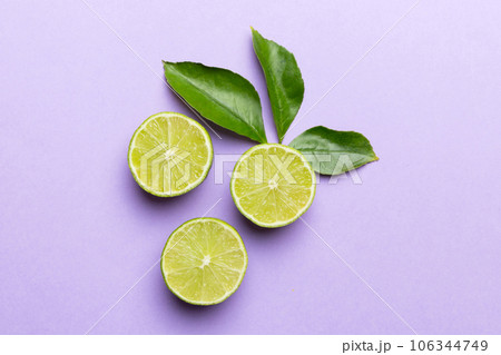 Lime fruits with green leaf and cut in half slice isolated on white background. Top view. Flat lay with copy space Lime fruits with green leaf and cut in half slice isolated on white background. Top view. Flat lay with copy space 106344749