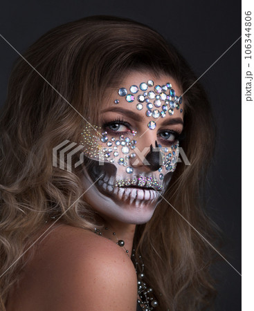 young woman with rhinestone makeup for Dia de los Muertos 106344806